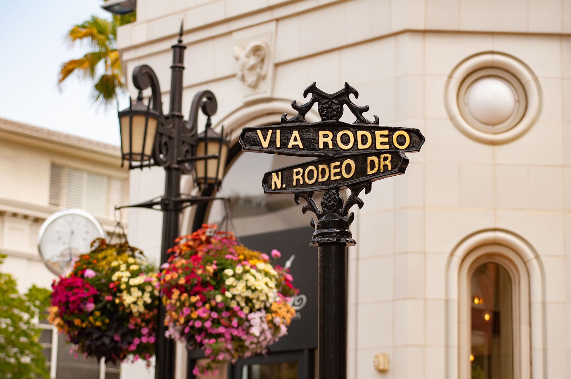 Iconic Rodeo Drive in Beverly Hills, lined with luxury boutiques and palm trees under blue skies.