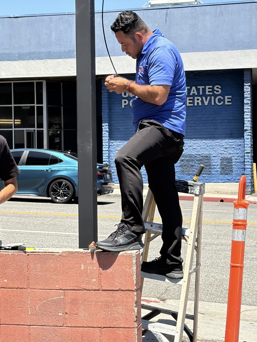 Alex, owner of American Valet Parking Response, installing a 180-degree overview parking camera at the entrance of a managed parking location