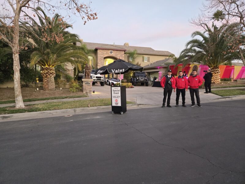 AVPR attendants in red jackets beside a special-event valet podium