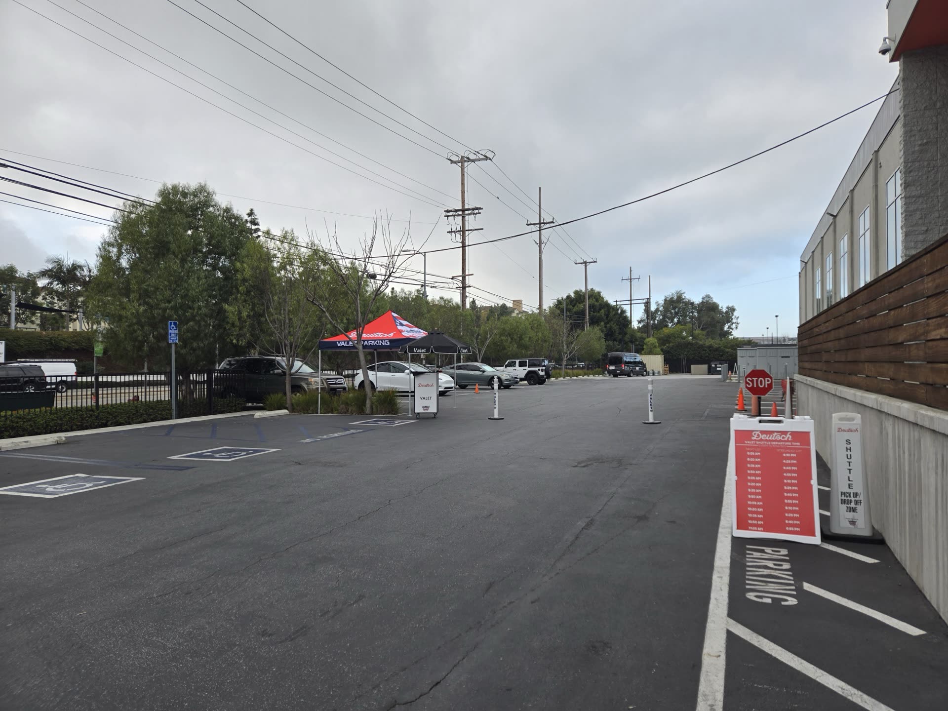 Parked vehicles beside a commercial building with cones and marked accessible spaces