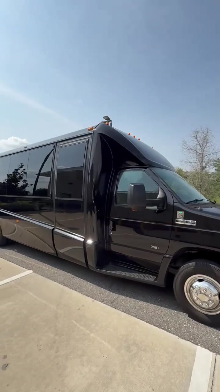 Passenger-side view of AVPR's black 24-passenger shuttle bus