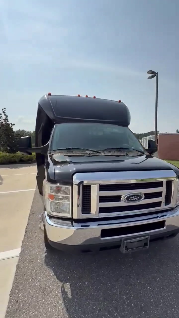 Three-quarter front view of AVPR's black 24-passenger shuttle bus