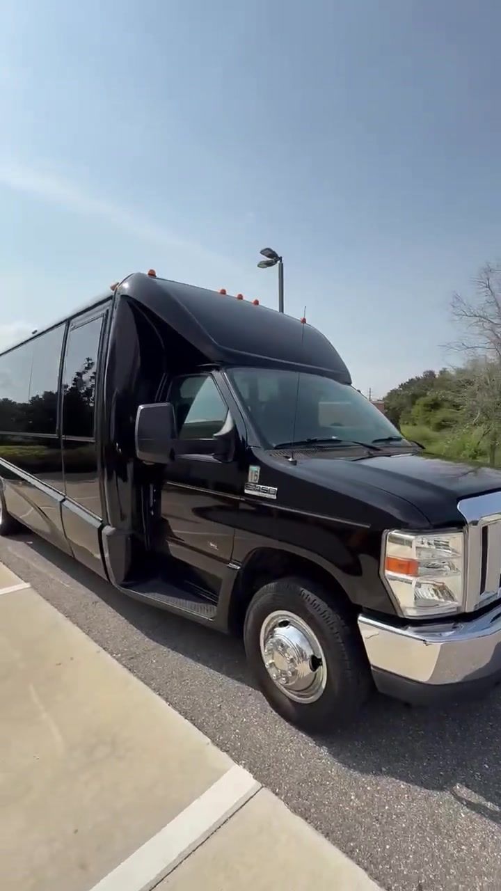 AVPR black 24-passenger luxury shuttle bus parked at a curb