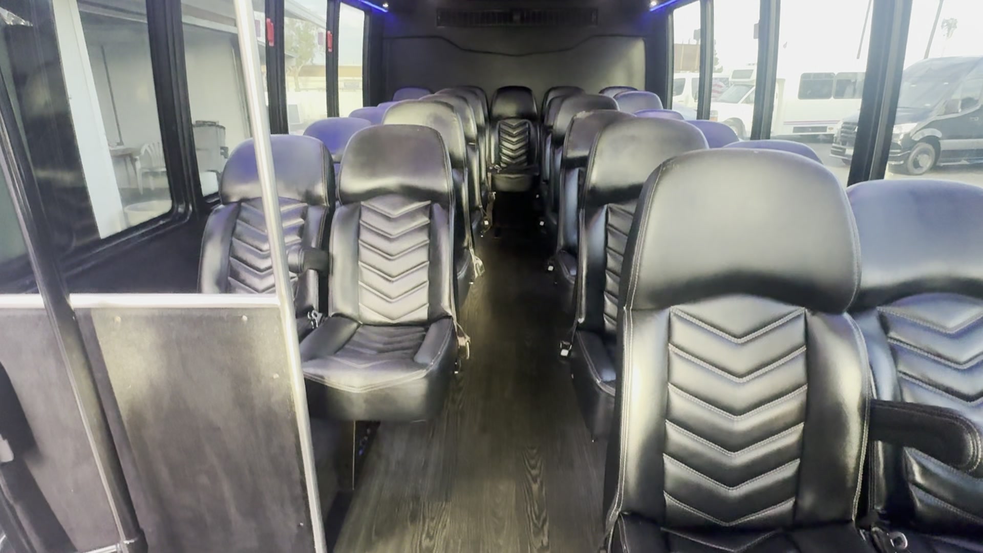 Forward-facing passenger seating and center aisle inside AVPR's black shuttle