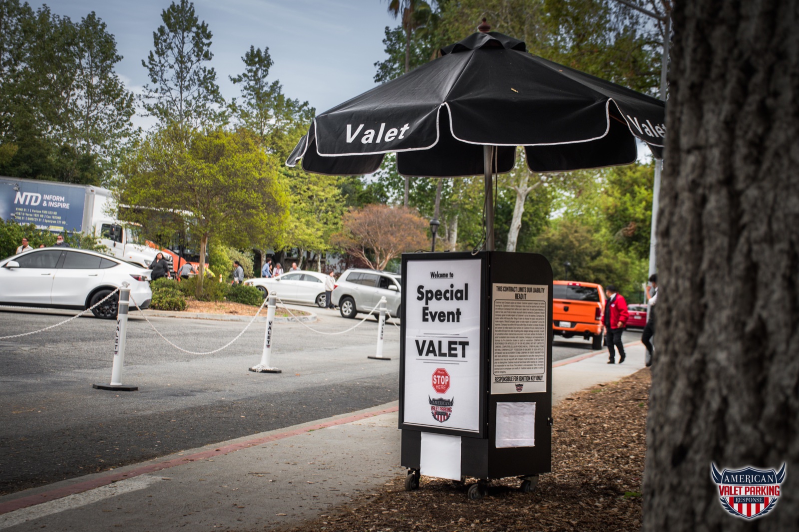Marked special event valet station with an umbrella and arrival lane