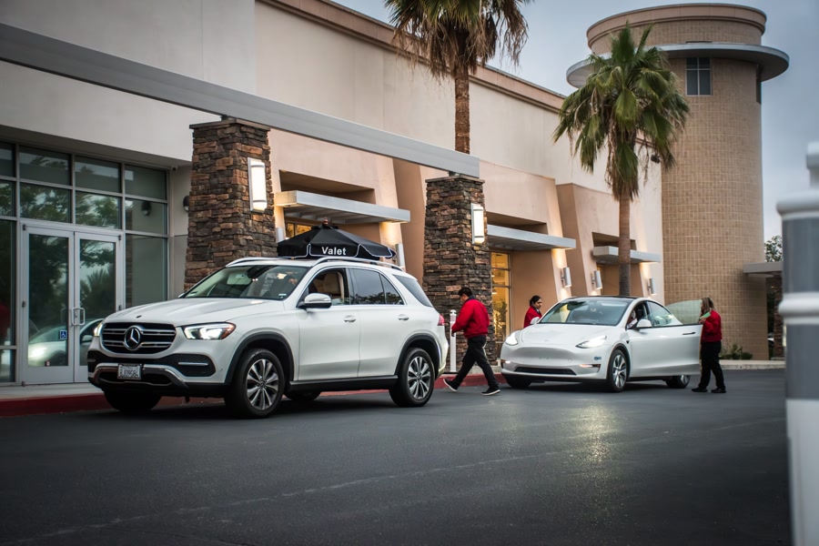 Valet attendants beside guest vehicles at a venue entrance