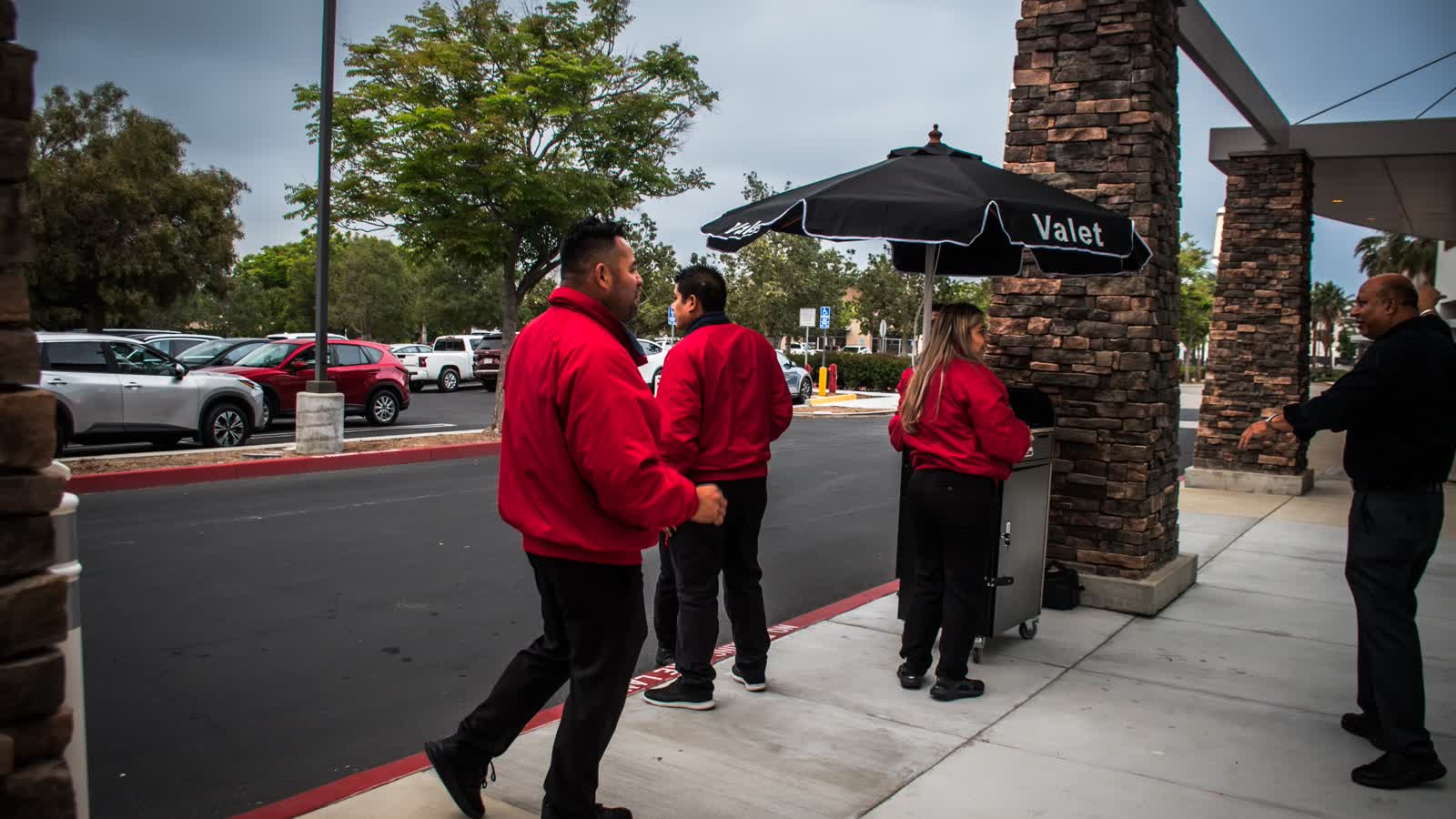 Valet team at a guest arrival station beneath a valet umbrella
